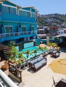a resort with a swimming pool and chairs and palm trees at Pousada Mirante da Prainha in Arraial do Cabo
