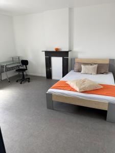 a bedroom with a bed and a desk and a table at Ans soleil in Ans
