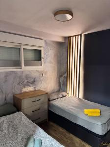 a bedroom with two beds and a desk with a yellow towel at ADOME Apartment Nautico IV in Santa Pola +41 photos