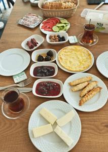 a table with white plates of food on it at Marigold Otel in Çeşme