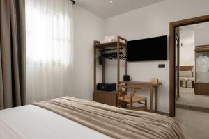 a bedroom with a bed and a desk and a television at Karavel Suites - Old Town in Rhodes Town