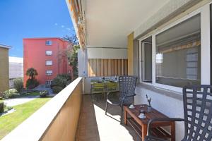 a balcony with chairs and a table on a building at Malibu46 - Minusio Apt with Shared Pool & Balcony - Happy Rentals in Minusio