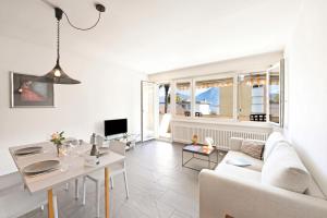 a living room with a white couch and a table at Malibu46 - Minusio Apt with Shared Pool & Balcony - Happy Rentals in Minusio