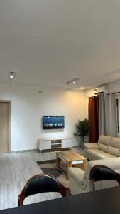 a living room with couches and a tv on a wall at Villa Princess Goofy in Lomé