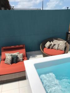 a hot tub and a couch next to a pool at Casa Arara vista mar - Por Pipa Casas de Praia in Pipa
