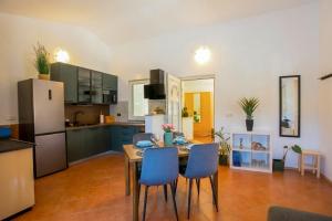 a kitchen with a table and chairs and a refrigerator at Casa Oliva Kim Marie /w Garden - Happy Rentals in Medulin