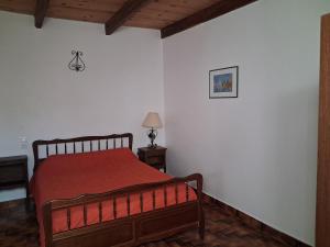 a bedroom with a bed with a red blanket at Gite du Fourbas in Belmont-Sainte-Foi