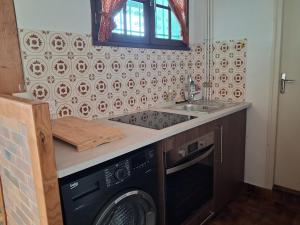 a kitchen with a washing machine and a sink at Gite du Fourbas in Belmont-Sainte-Foi