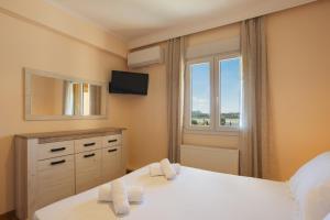 a bedroom with a large bed and a window at Maisonette ELINA in Corfu