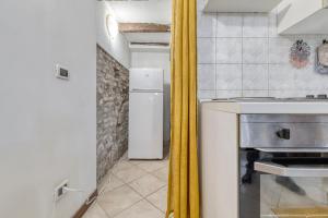 a kitchen with a white refrigerator and a yellow curtain at Alessia House in Ferrara +11 photos