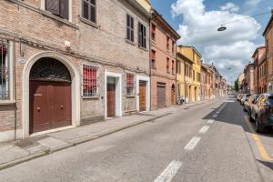 an empty city street with buildings and cars parked at Alessia House in Ferrara
