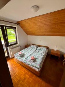 a bedroom with a bed and a wooden ceiling at Bohinjski kot in Bohinj