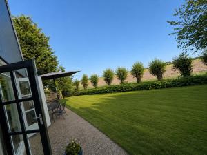 a view of a lawn with a house at Holiday Home de Binnengouw incl Hottub in Hoogwoud