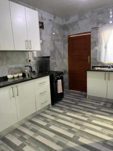 a kitchen with white cabinets and a stove at Nana Kay's apartment in Livingstone
