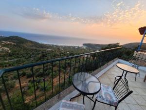 a balcony with a table and chairs and the ocean at Jannis Castle Apartment in Himare