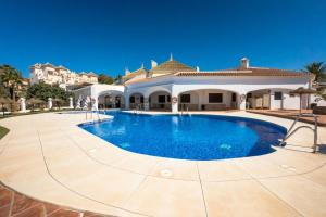 a large swimming pool in front of a house at Casa Merlin Capistrano playa in Nerja