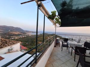 a balcony with a table and chairs overlooking the ocean at Jannis Castle Apartment in Himare +24 photos