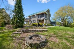 a house with a fire pit in the yard at Topaz Beach Cottage AC Waterview in Wiarton
