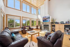 a living room with leather furniture and a fireplace at Topaz Beach Cottage AC Waterview in Wiarton