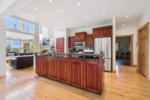 a kitchen with wooden cabinets and a living room at Topaz Beach Cottage AC Waterview in Wiarton