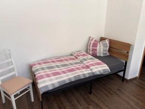 a small bed with a blanket and a chair in a room at Ferienwohnung Goldener Hirsch in Schneeberg