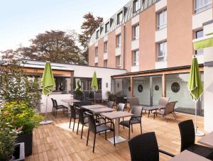 a patio with tables and chairs and a building at ibis Styles Beaune Centre in Beaune