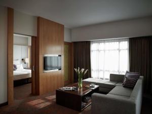 a living room with a couch and a tv at Pullman Hanoi in Hanoi