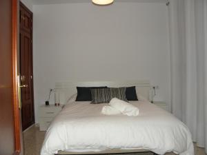 1 dormitorio con 1 cama blanca y 2 almohadas en Apartamento en Jerez de la Frontera 2, en Jerez de la Frontera