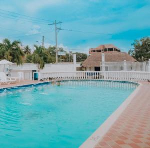 a swimming pool with a white fence and blue water at Kevin's in Tolú