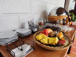 a bowl of fruit sitting on a table with plates at Park Place Hotel in Siguatepeque