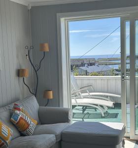 a living room with a couch and a balcony at Ocean panorama in Farsund