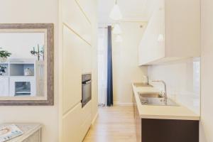 a kitchen with white cabinets and a sink at Sopot Monte Cassino Wiktoria Apt in Sopot +2 photos