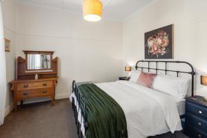 a bedroom with a bed and a dresser and a mirror at Queenie's Cottage in Mansfield