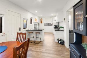 a kitchen and dining room with a wooden table and chairs at Queenie's Cottage in Mansfield