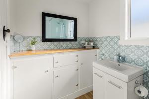 a bathroom with a sink and a mirror on the wall at Queenie's Cottage in Mansfield