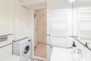 a white bathroom with a washing machine and a sink at Sopot Monte Cassino Wiktoria Apt in Sopot