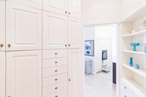 a white kitchen with white cabinets and a television at Sopot Monte Cassino Wiktoria Apt in Sopot