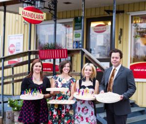 un grupo de personas sosteniendo pasteles con velas en Bo på Lanthandel, en Norråker