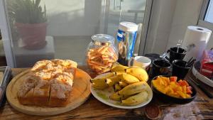 a table topped with a plate of bread and fruit at Refúgio Vida & Brisa in Pelotas