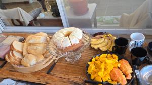 a table with a bunch of different types of bread and fruit at Refúgio Vida & Brisa in Pelotas