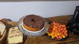 a table with a chocolate cake and a plate of fruit at Refúgio Vida & Brisa in Pelotas +29 photos