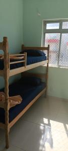 two bunk beds in a room with a window at Apê d'praia 31 - Beira Mar Bertioga in Bertioga