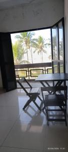 a picnic table and chairs in front of a window at Apê d'praia 31 - Beira Mar Bertioga in Bertioga