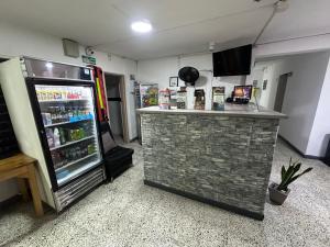 a bar in a room with a refrigerator at hotel guayacanes central in Medellín