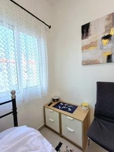 a bedroom with a desk and a bed and a window at Apartament Słoneczny in Skala Fourkas