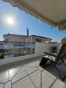 a chair on a balcony with a view of a building at Apartament Słoneczny in Skala Fourkas