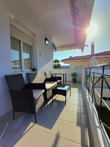 a patio with a couch and chairs on a balcony at Apartament Słoneczny in Skala Fourkas