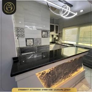 a kitchen with a black counter top in a room at السعودي للشقق الفندقيه in Az Zarqa