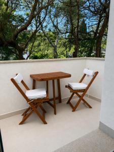 two chairs and a wooden table on a balcony at Minnanni in San Pantaleo