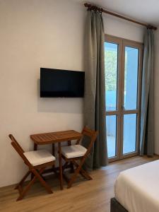 a room with a table and chairs and a television at Minnanni in San Pantaleo